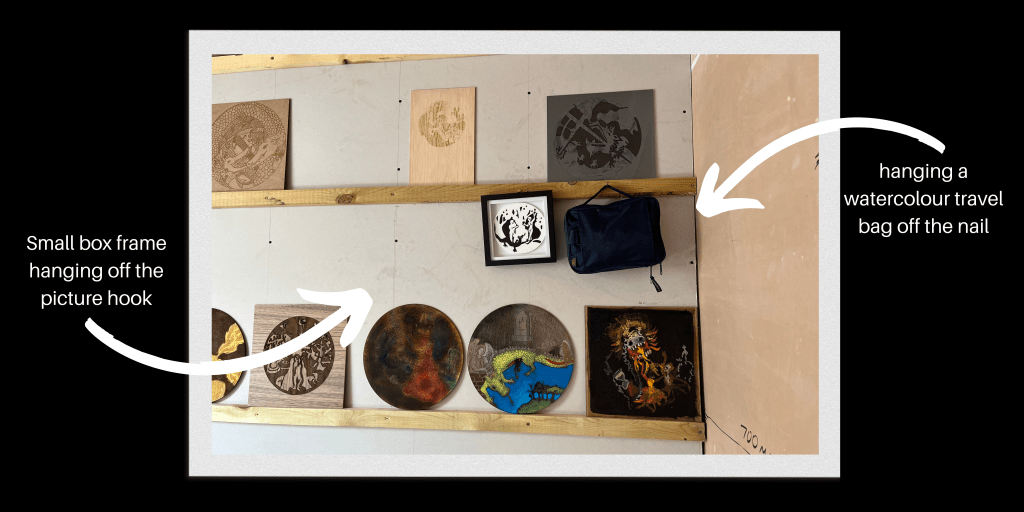 Art studio hanging and storage system showing storage bag and small framed work