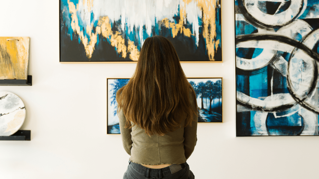 the traditional art gallery with paintings and women looking sitting down