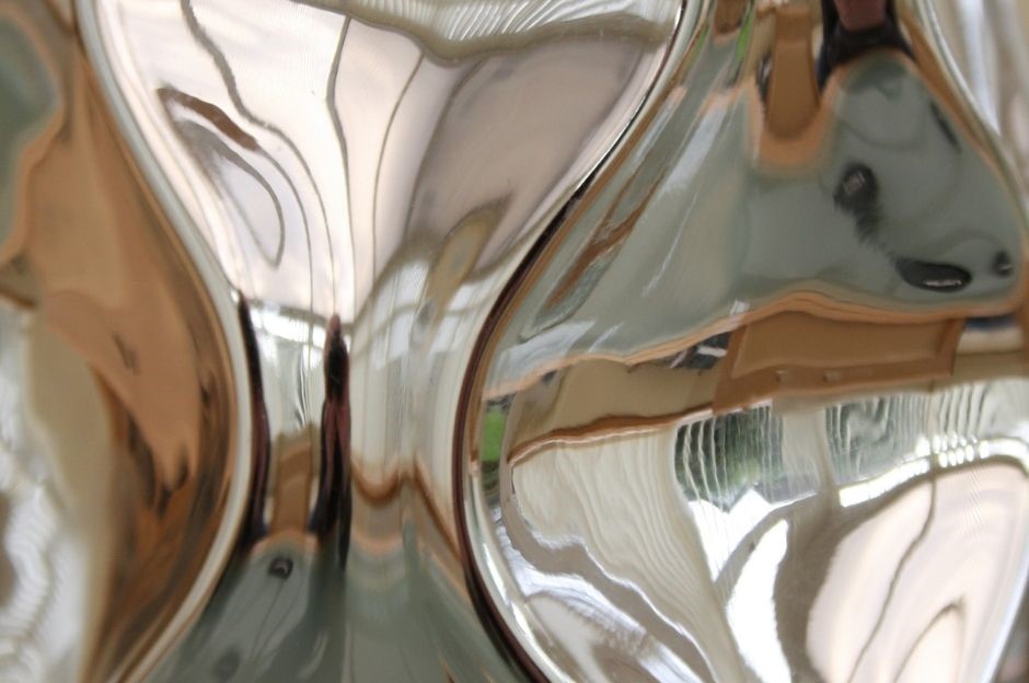 silver metallic mirror surface with reflection of photographer inside