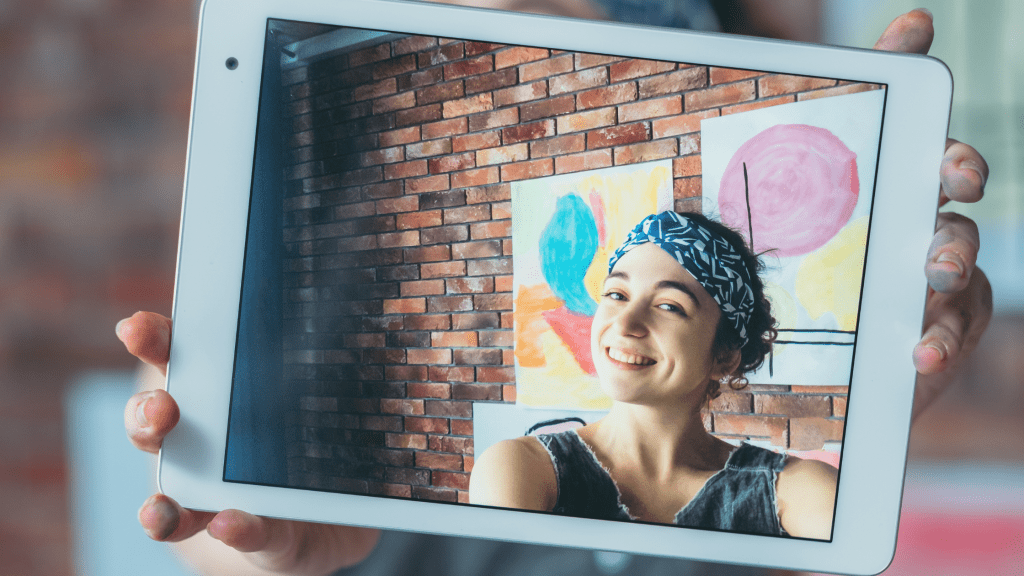 content creator and artist taking photo with paint hands of her artworks