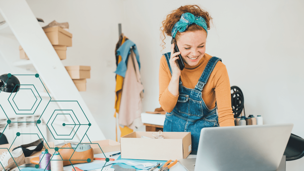artist with an online presence near stairs with phone, laptop and boxes